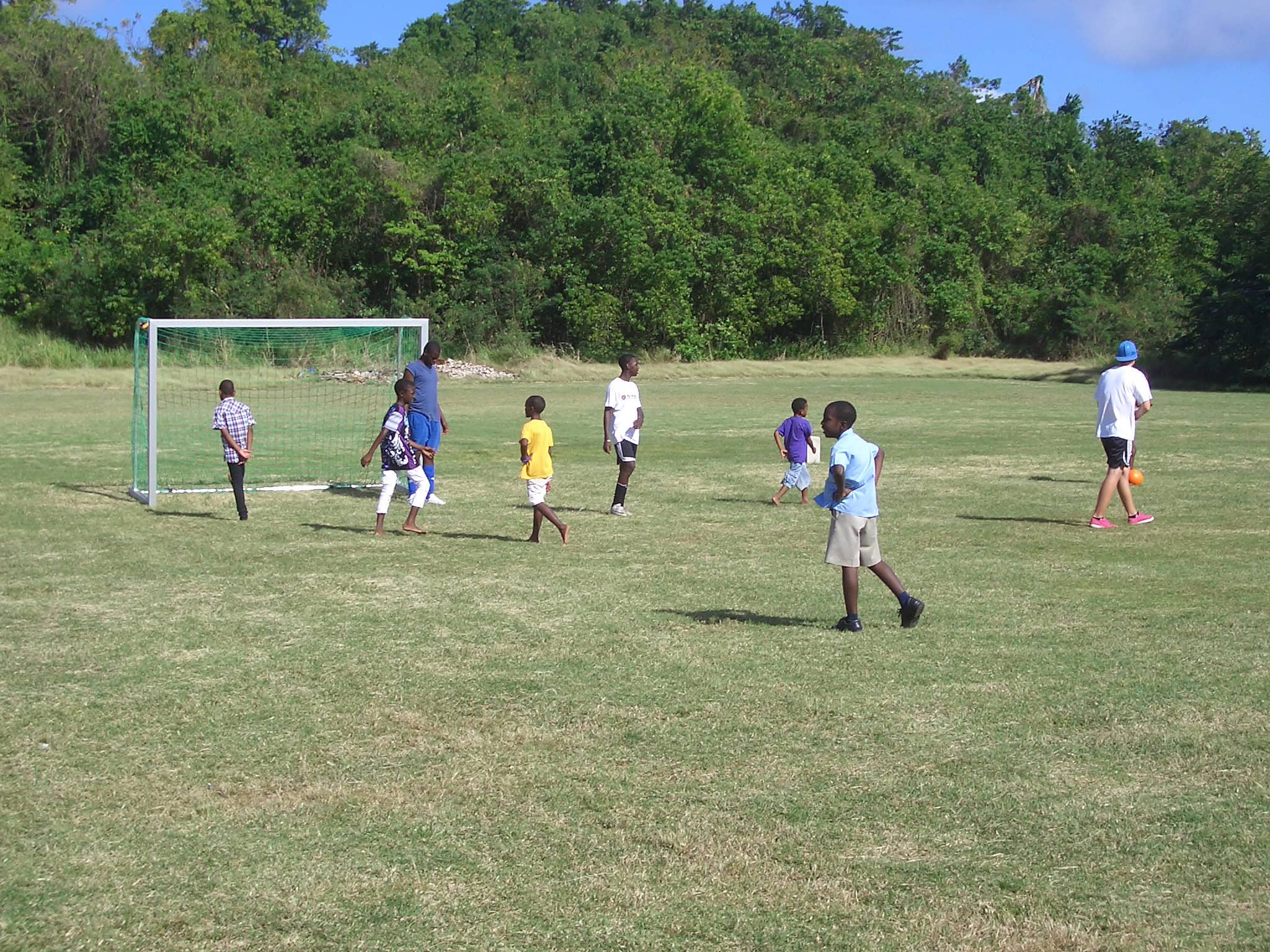 Kinder aus Barbados spielen Fußball auf einem Sport-Thieme Tor.
