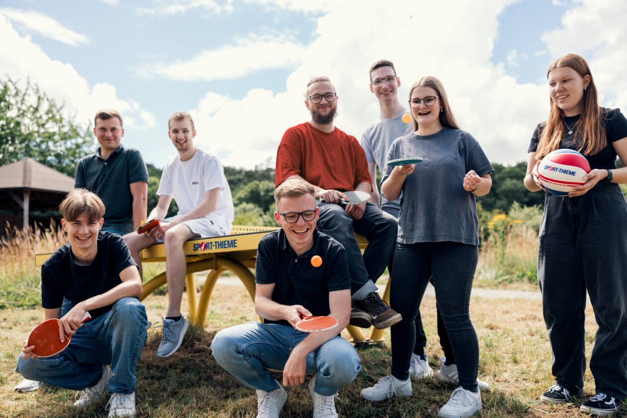 Trainees stand together with various games on the trainee trip.