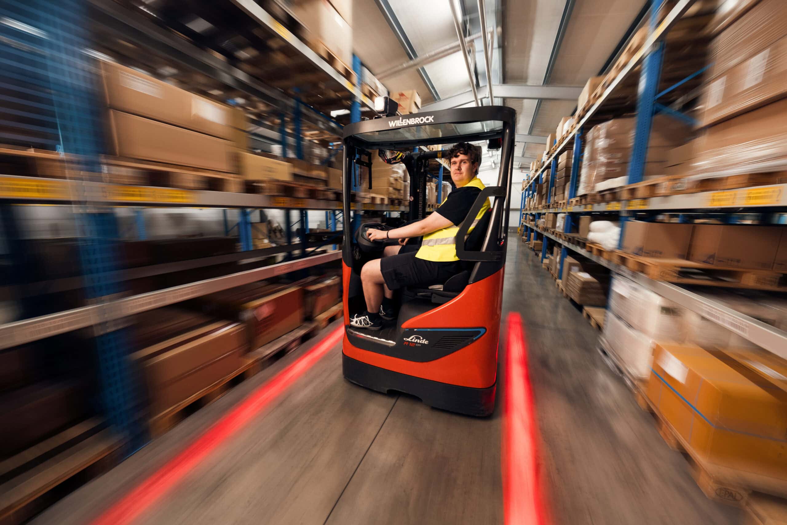 Logistics trainee driving a forklift in the warehouse.