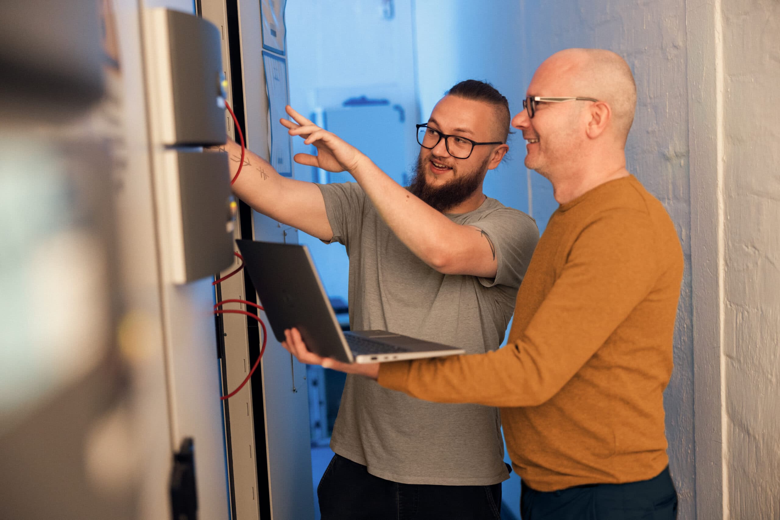 IT trainee and colleague working on a server rack.