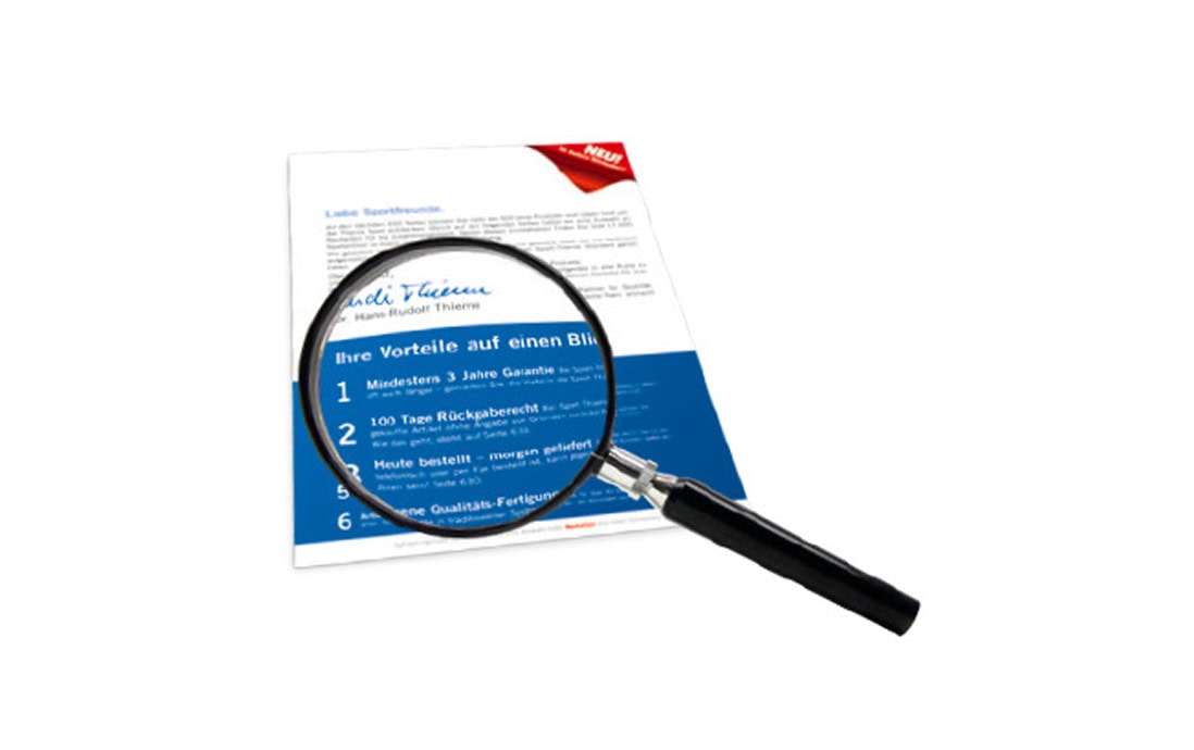 An informational brochure outlining the benefits of Sport-Thieme, placed under a magnifying glass.