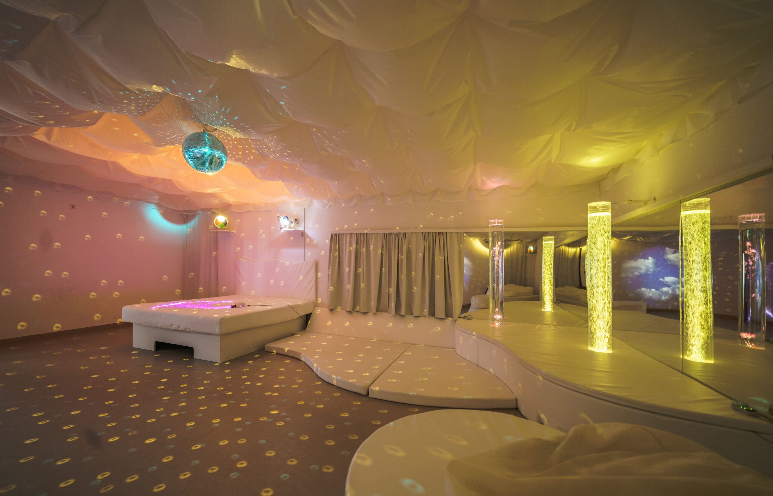 A Snoezelen room with many different light sources and a relaxed atmosphere.