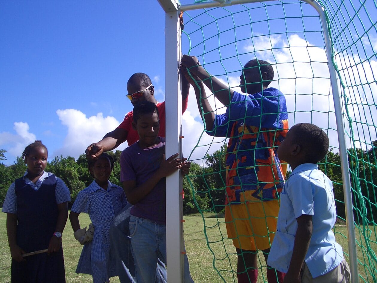 Teenagers from Barbados fixing the net of the goal