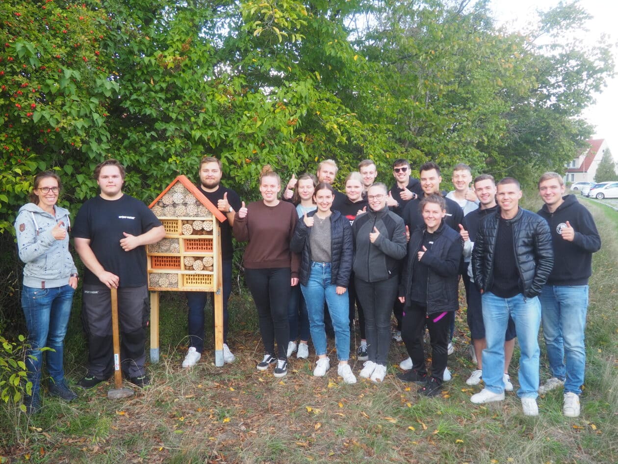 Group photo of the Sport-Thieme trainees with the insect hotel.